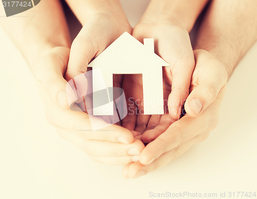 Image of woman and hands with paper house