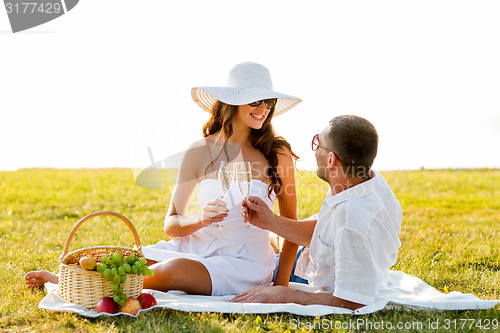 Image of smiling couple drinking champagne on picnic