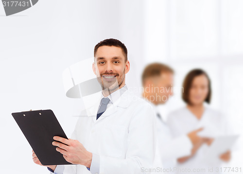 Image of smiling male doctor with clipboard