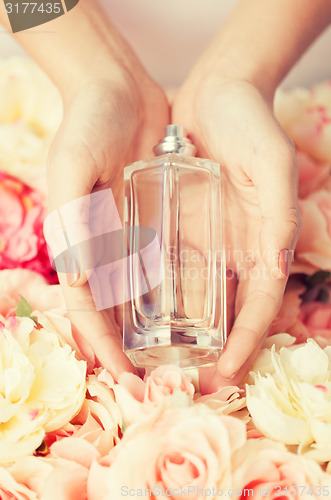 Image of woman\'s hands showing perfume