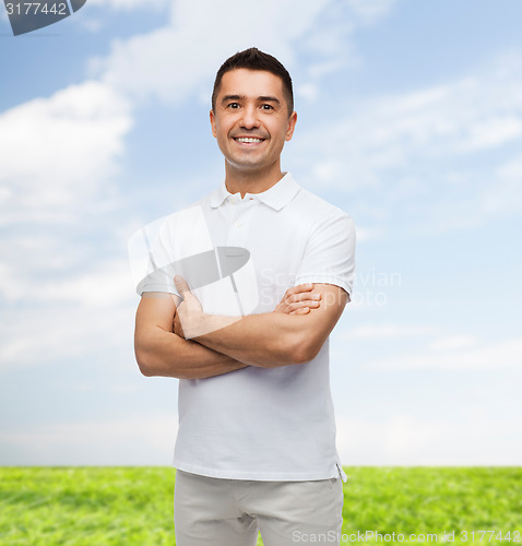 Image of smiling man in white t-shirt with crossed arms