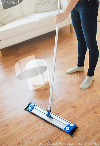 Image of close up of woman with mop cleaning floor at home