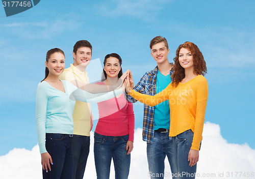 Image of smiling teenagers making high five