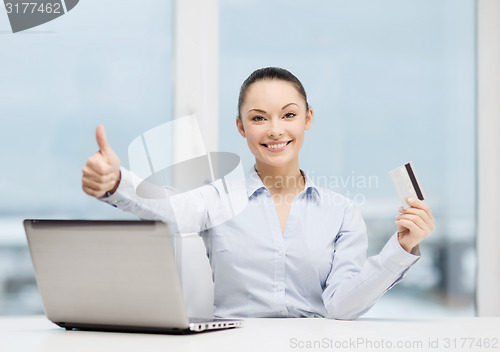 Image of businesswoman with laptop in office