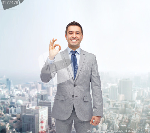 Image of happy businessman in suit showing ok hand sign