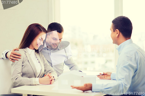 Image of couple looking at model of their house at office