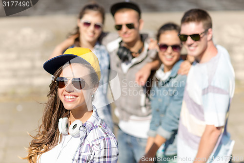 Image of teenage girl with headphones and friends outside
