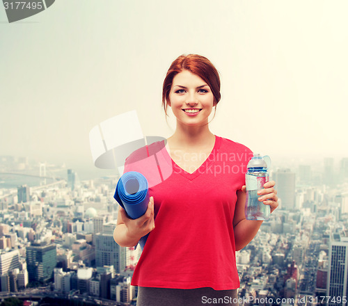 Image of smiling girl with bottle of water after exercising