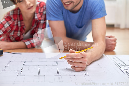 Image of close up of couple with  blueprint at home