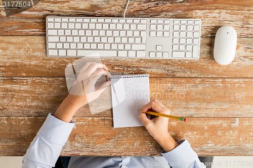 Image of close up of hands with notebook and keyboard