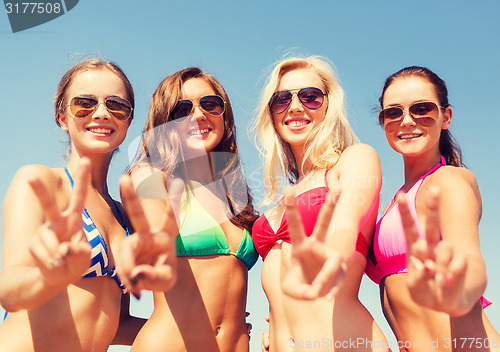 Image of group of smiling young women on beach