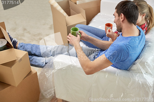 Image of happy couple relaxing on sofa in new home