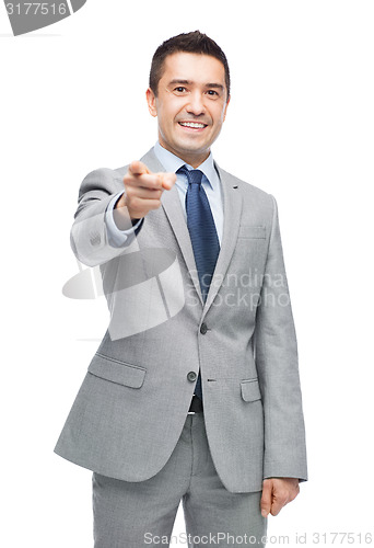 Image of happy smiling businessman in suit pointing at you