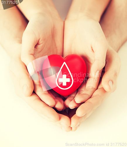 Image of hands holding red heart with donor sign