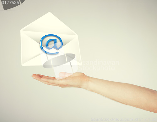 Image of hand holding envelope with email sign