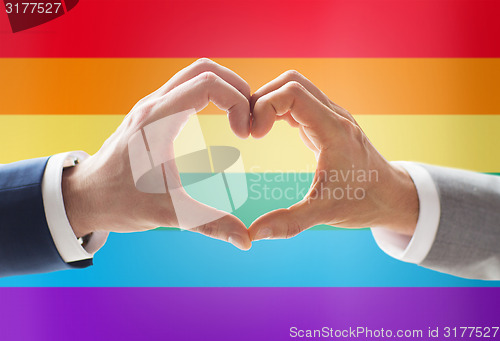 Image of close up of male gay couple hands showing heart