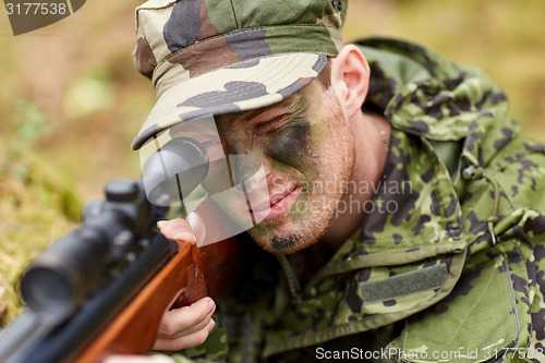 Image of soldier or hunter shooting with gun in forest