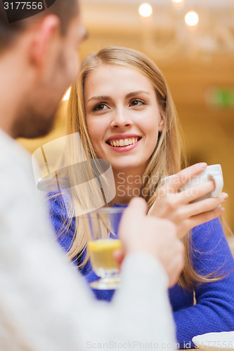 Image of happy couple dating and drinking tea at cafe