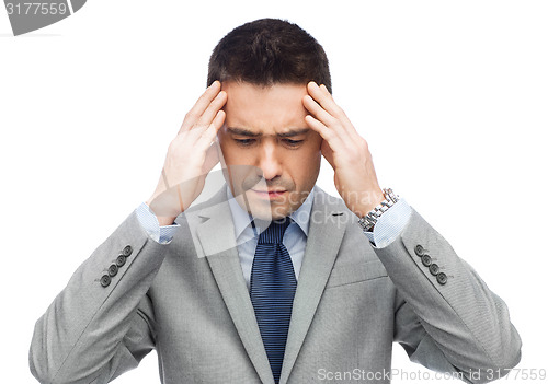 Image of businessman in suit having head ache