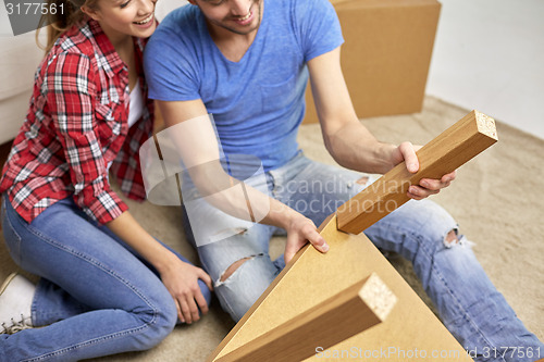 Image of close up of couple unpacking furniture and moving