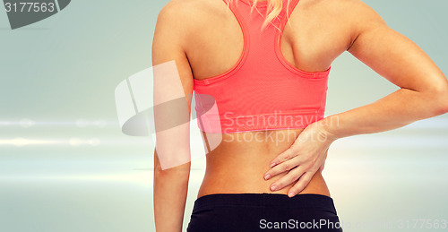 Image of close up of sporty woman touching her back