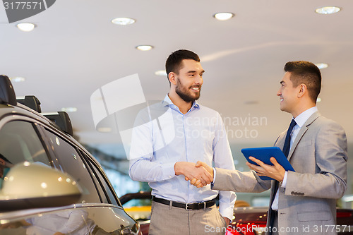 Image of happy man shaking hands in auto show or salon