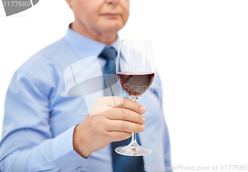 Image of close up of senior man holding glass with red wine