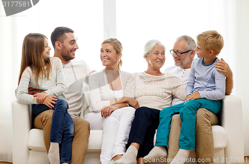 Image of happy family sitting on couch at home