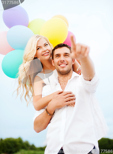 Image of couple with colorful balloons at sea side