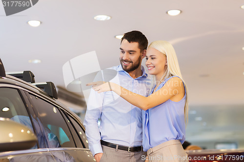 Image of happy couple buying car in auto show or salon