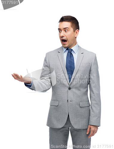 Image of shocked businessman in suit looking to empty hand