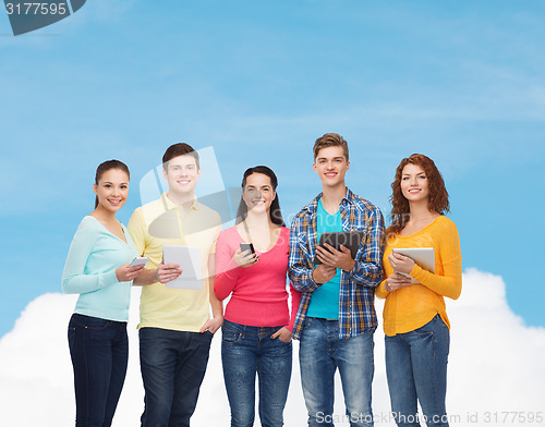 Image of group of teenagers with smartphones and tablet pc