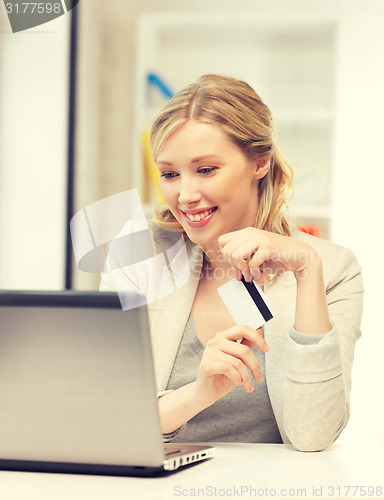 Image of happy woman with laptop computer and credit card