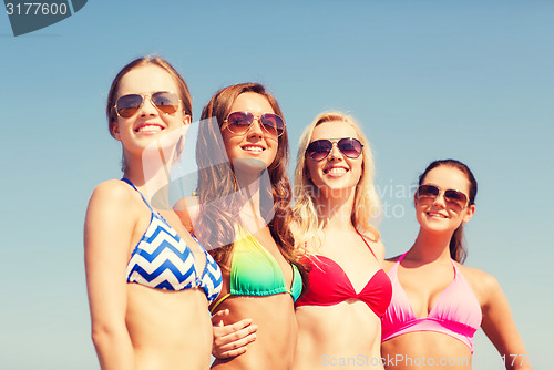 Image of group of smiling young women on beach