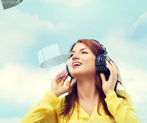 Image of smiling young girl in headphones at home