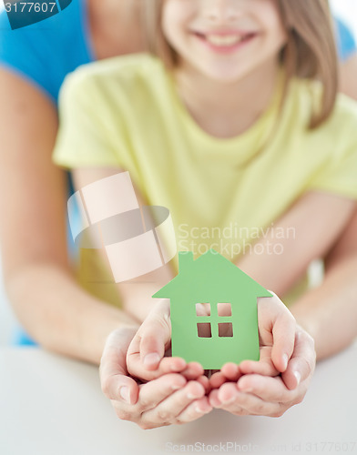 Image of close up of woman and girl hands with paper house