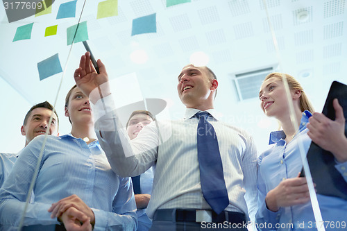 Image of smiling business people with marker and stickers