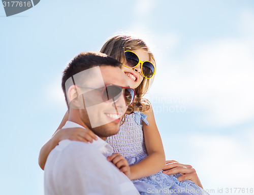 Image of happy father and child in sunglasses over blue sky