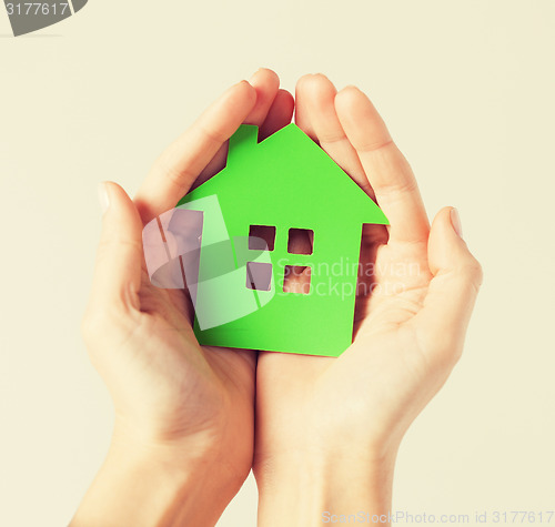 Image of hands holding green house