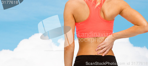 Image of close up of sporty woman touching her back