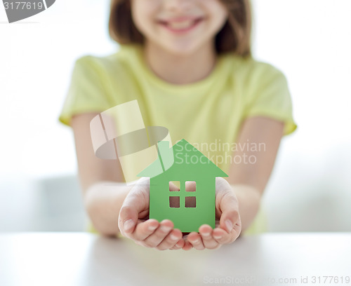 Image of close up of happy girl hands holding paper house