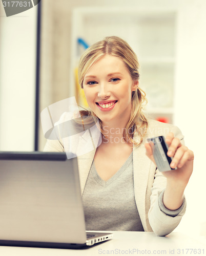 Image of happy woman with laptop computer and credit card