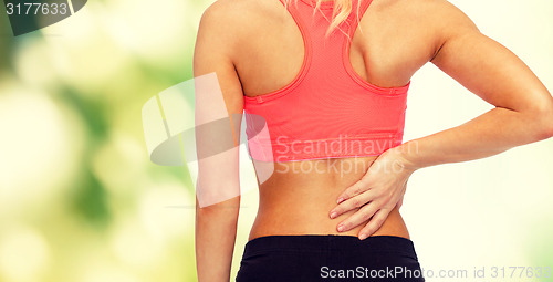 Image of close up of sporty woman touching her back