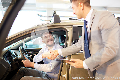 Image of happy man with car dealer in auto show or salon