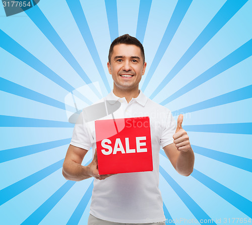 Image of smiling man with red sale sigh showing thumbs up