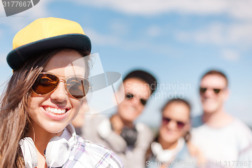 Image of teenage girl with headphones and friends outside