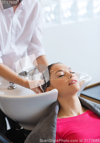 Image of happy young woman at hair salon