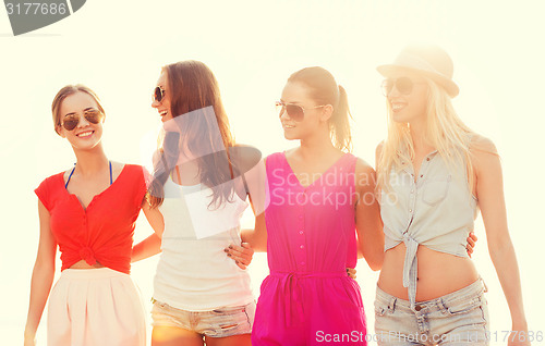 Image of group of smiling women in sunglasses on beach