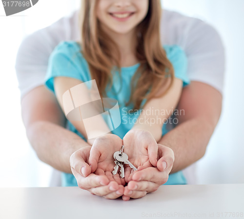 Image of close up of man and girl hands with house keys