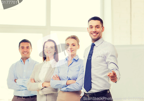 Image of businessman in office pointing finger at you